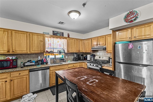 kitchen featuring tasteful backsplash, visible vents, under cabinet range hood, stainless steel appliances, and a sink