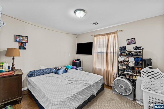 bedroom featuring wood finished floors and visible vents