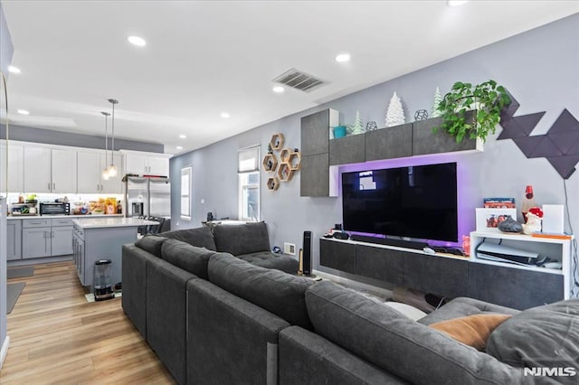 living area featuring recessed lighting, visible vents, and light wood-style floors