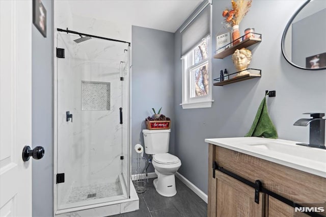 full bathroom with a marble finish shower, baseboards, toilet, and vanity