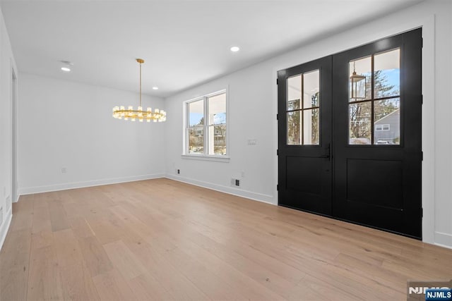 entryway with baseboards, light wood-style flooring, recessed lighting, french doors, and a notable chandelier