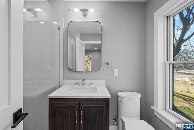 bathroom featuring vanity, toilet, and plenty of natural light