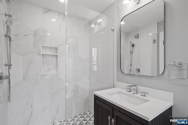 full bathroom with vanity and a marble finish shower