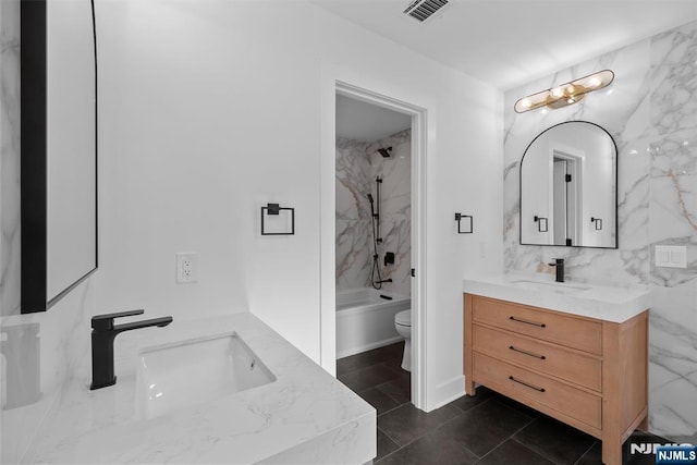 bathroom with visible vents, toilet, tile walls, washtub / shower combination, and vanity