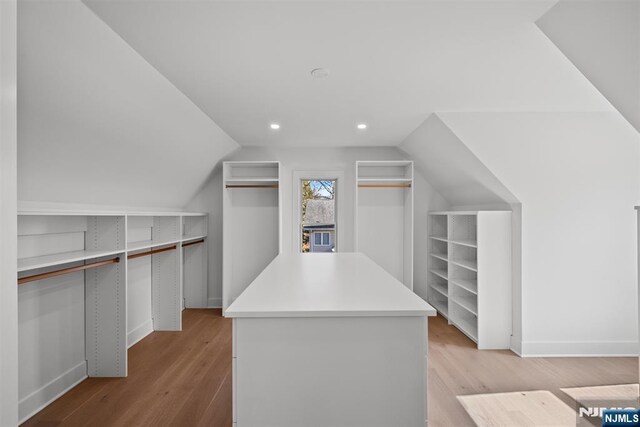 walk in closet with lofted ceiling and wood finished floors