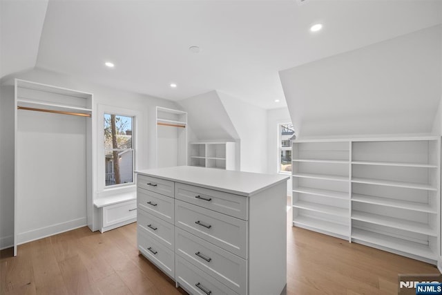 spacious closet featuring light wood-type flooring and vaulted ceiling