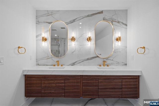 full bath featuring a sink, decorative backsplash, a marble finish shower, and double vanity