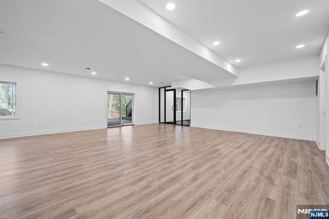 unfurnished living room with recessed lighting, light wood-style floors, and baseboards