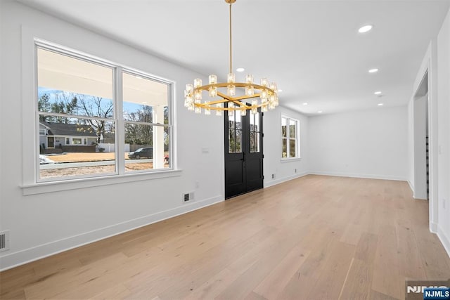 interior space featuring baseboards, visible vents, recessed lighting, light wood-style floors, and a notable chandelier