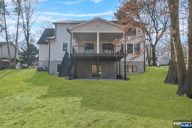 rear view of property with cooling unit, a yard, stairs, and a patio area