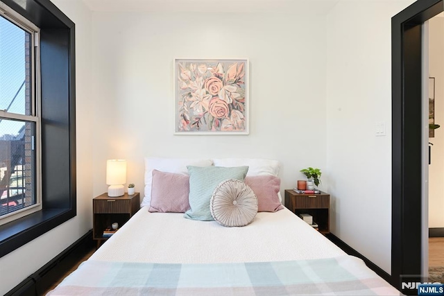 bedroom with wood finished floors and baseboards