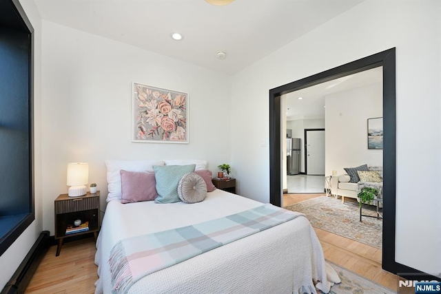 bedroom featuring recessed lighting, freestanding refrigerator, and light wood-style floors