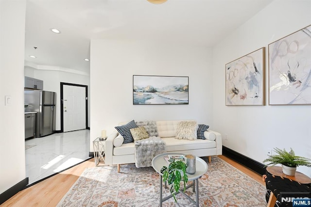 living room with recessed lighting, baseboards, and light wood finished floors