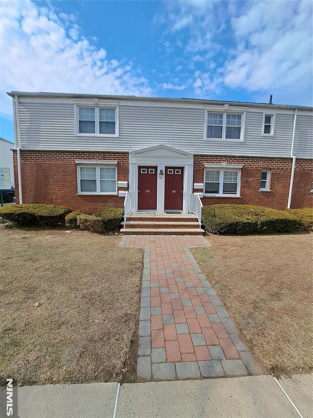 view of front facade with brick siding and entry steps