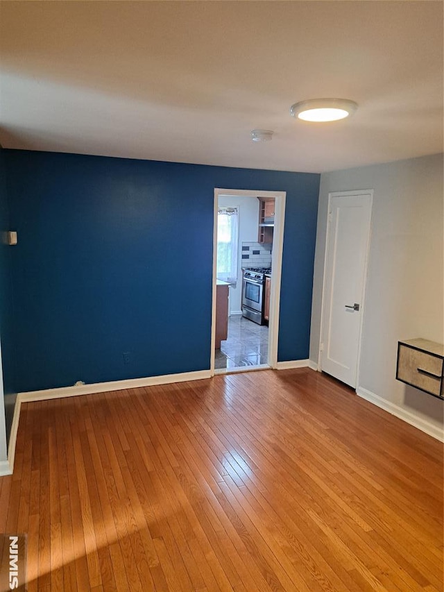 empty room featuring baseboards and wood-type flooring