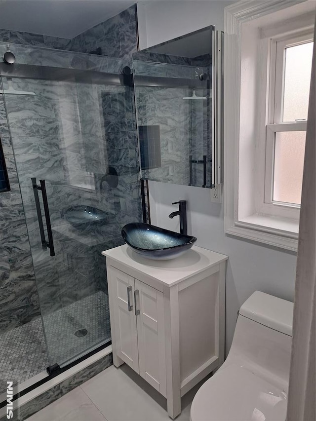 full bath with a marble finish shower, toilet, and vanity