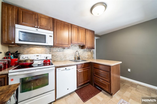 kitchen featuring white appliances, baseboards, a sink, light countertops, and tasteful backsplash