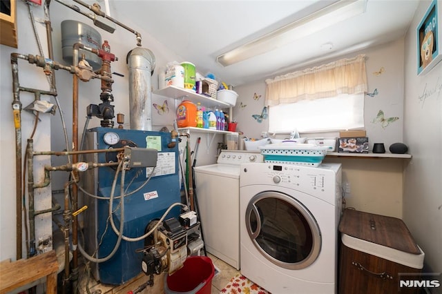 laundry room with laundry area, a heating unit, and washing machine and clothes dryer