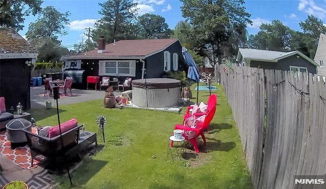 view of yard with a patio area, a fenced backyard, and a hot tub