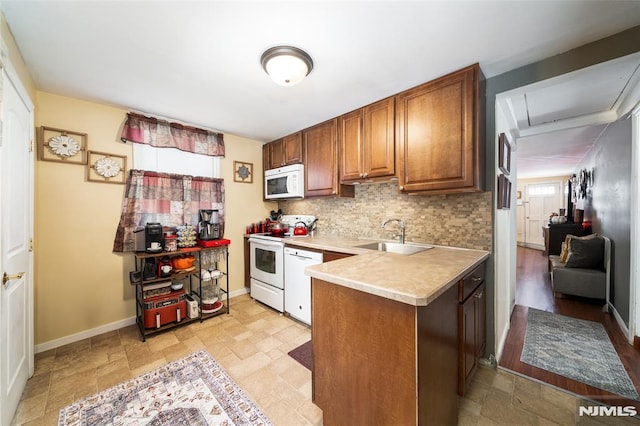 kitchen with white appliances, brown cabinetry, a sink, light countertops, and backsplash