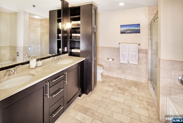 full bathroom featuring a sink, tile walls, and a shower stall