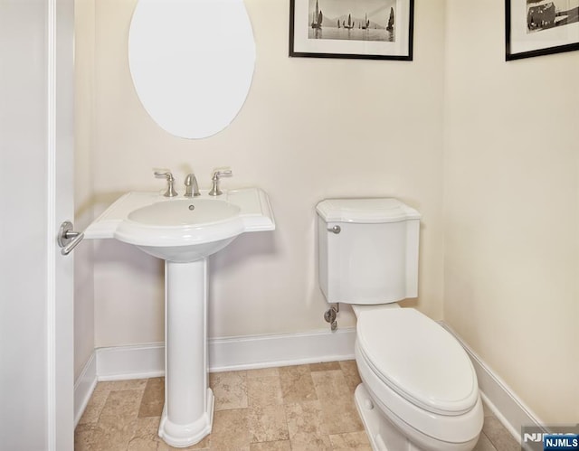 half bathroom with toilet and baseboards