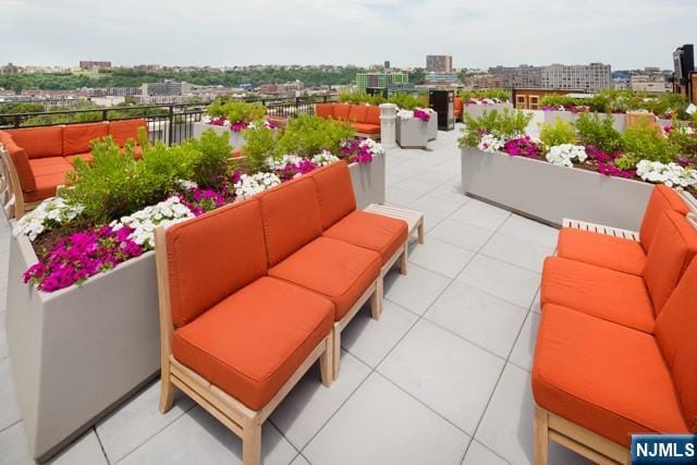 balcony with an outdoor living space, a city view, and a patio area