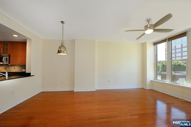 interior space featuring recessed lighting, light wood-type flooring, baseboards, and ceiling fan