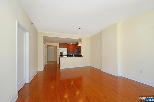 unfurnished living room featuring light wood-style floors and baseboards