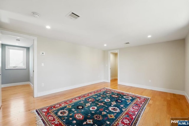 unfurnished room featuring light wood-style floors, visible vents, baseboards, and recessed lighting