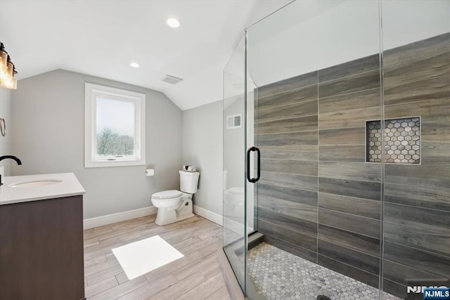 full bathroom featuring toilet, visible vents, wood finished floors, and a stall shower