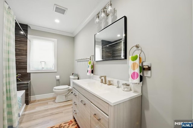 bathroom with toilet, wood finished floors, vanity, visible vents, and baseboards