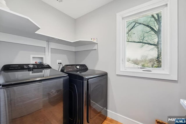 laundry room featuring laundry area, wood finished floors, baseboards, and washer and dryer