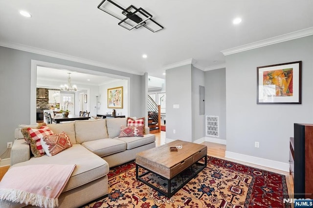 living area with a notable chandelier, crown molding, and recessed lighting