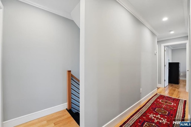 hall featuring baseboards, an upstairs landing, and wood finished floors
