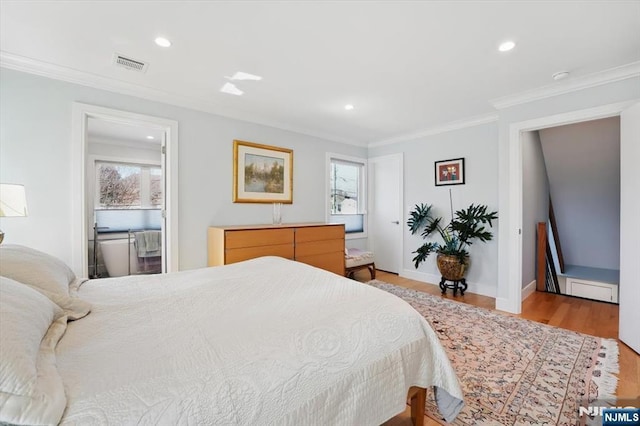 bedroom with multiple windows, visible vents, light wood-style flooring, and crown molding