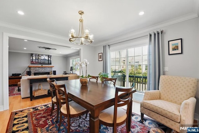 dining area featuring recessed lighting, crown molding, light wood-type flooring, and a notable chandelier