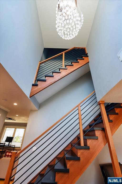 stairway with a chandelier and a towering ceiling