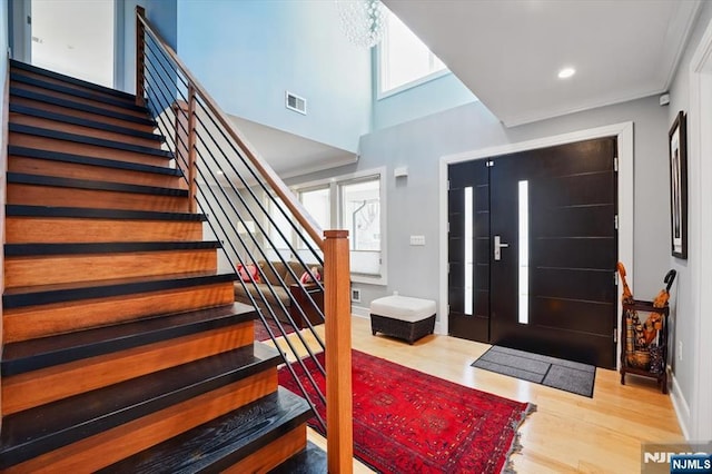 entrance foyer featuring plenty of natural light, visible vents, wood finished floors, and stairs