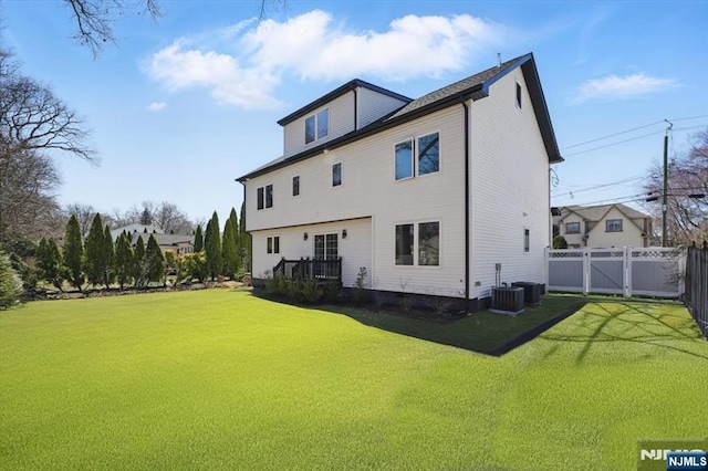 back of property with fence and a lawn
