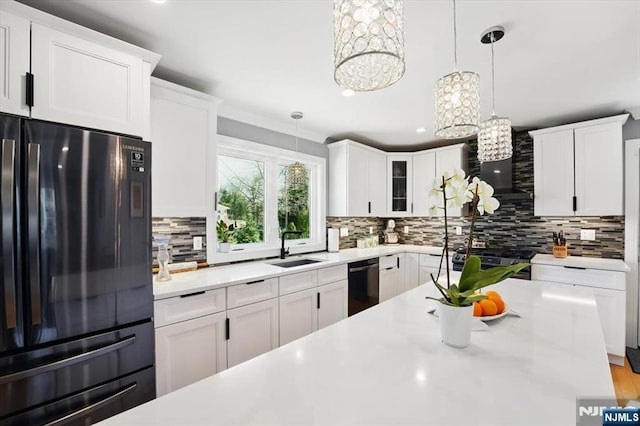 kitchen with black appliances, a notable chandelier, light countertops, and tasteful backsplash