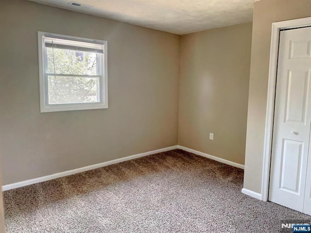 carpeted empty room with baseboards