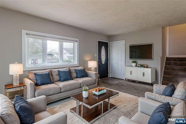 living area featuring carpet and stairs