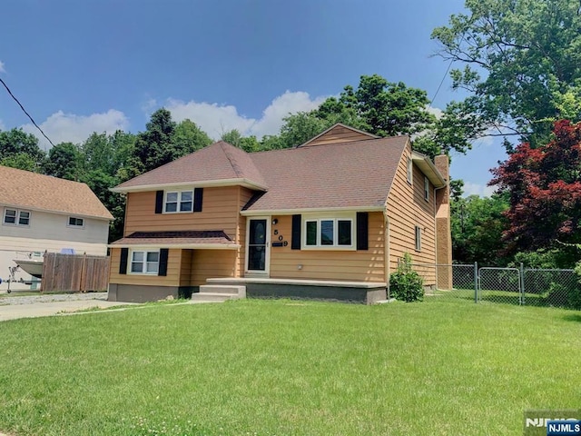 tri-level home with a gate, a chimney, a front yard, and fence