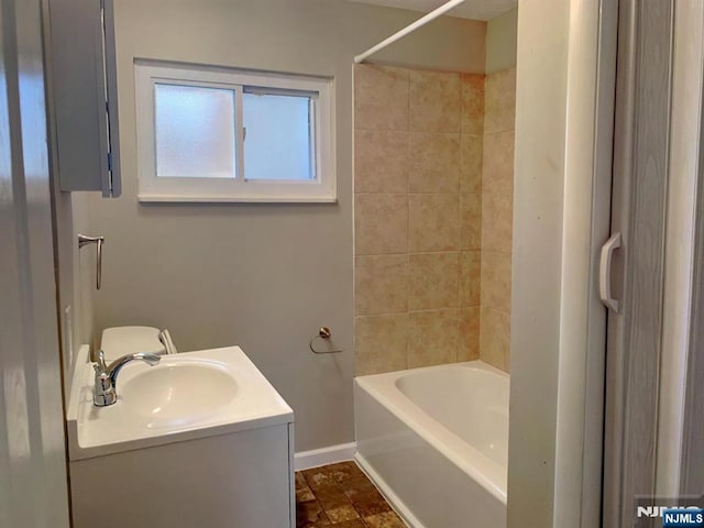 bathroom featuring baseboards, shower / washtub combination, and vanity