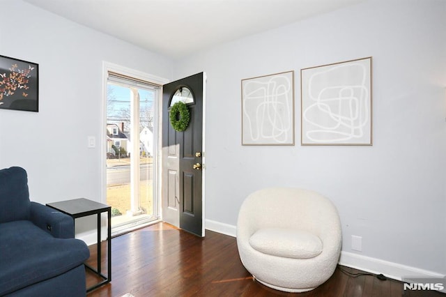 living area featuring baseboards and wood finished floors