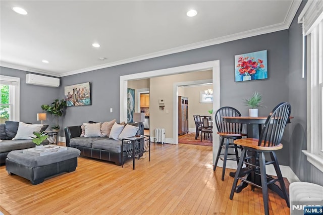living area featuring light wood-style floors, crown molding, baseboards, an AC wall unit, and radiator heating unit