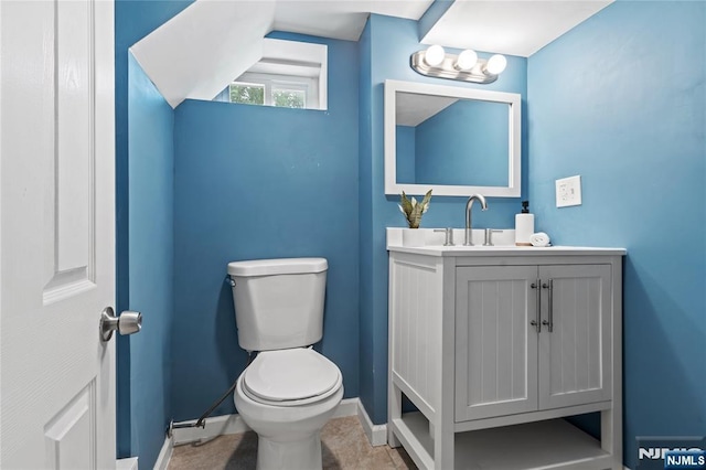 bathroom featuring toilet, baseboards, and vanity