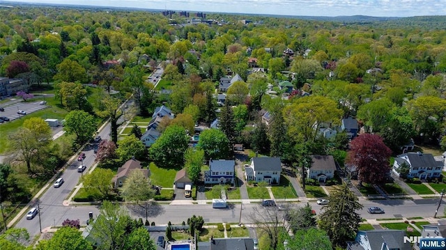 drone / aerial view with a wooded view and a residential view