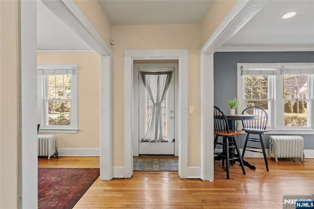interior space with baseboards, ornamental molding, radiator, and hardwood / wood-style flooring